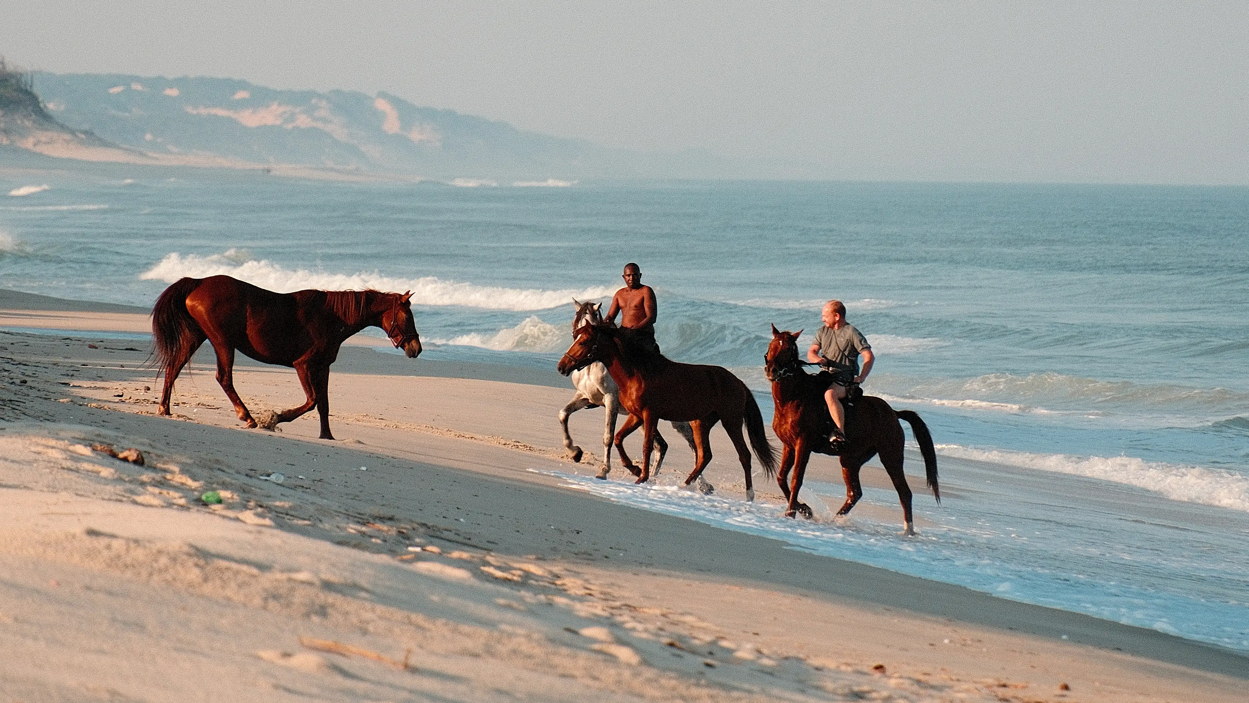 Horses and riders on the empty beaches of Calanga