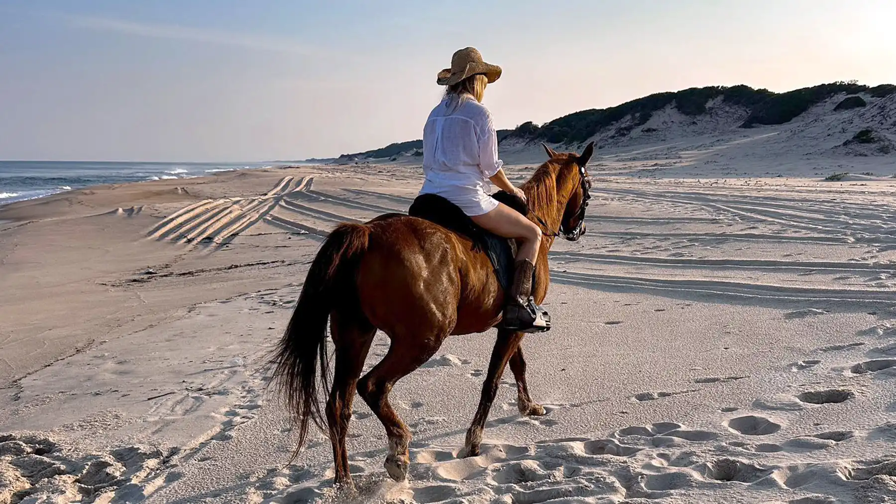 Guest riding on the beach as sunset